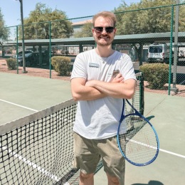 a person holding a racket on a tennis court