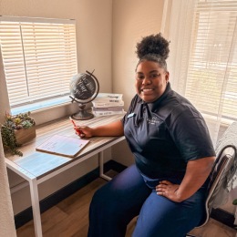 a person sitting at a desk smiling