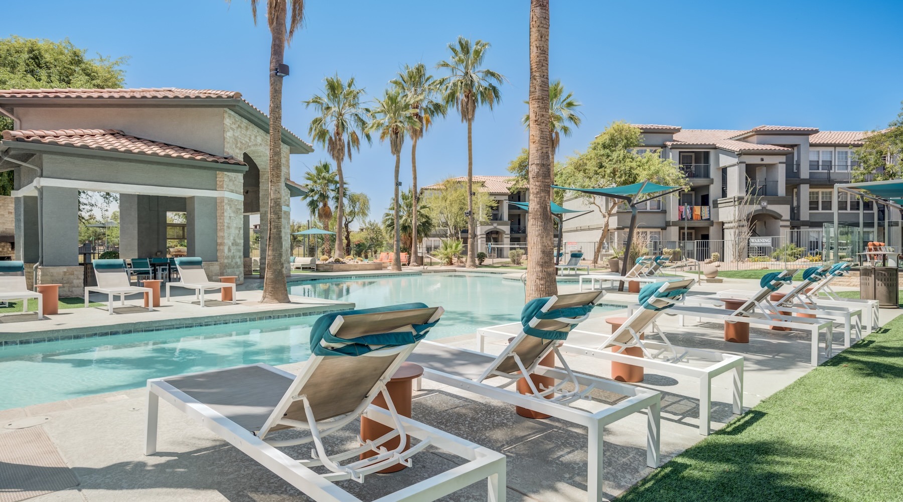 resort style pool with seating and palm trees  in a courtyard